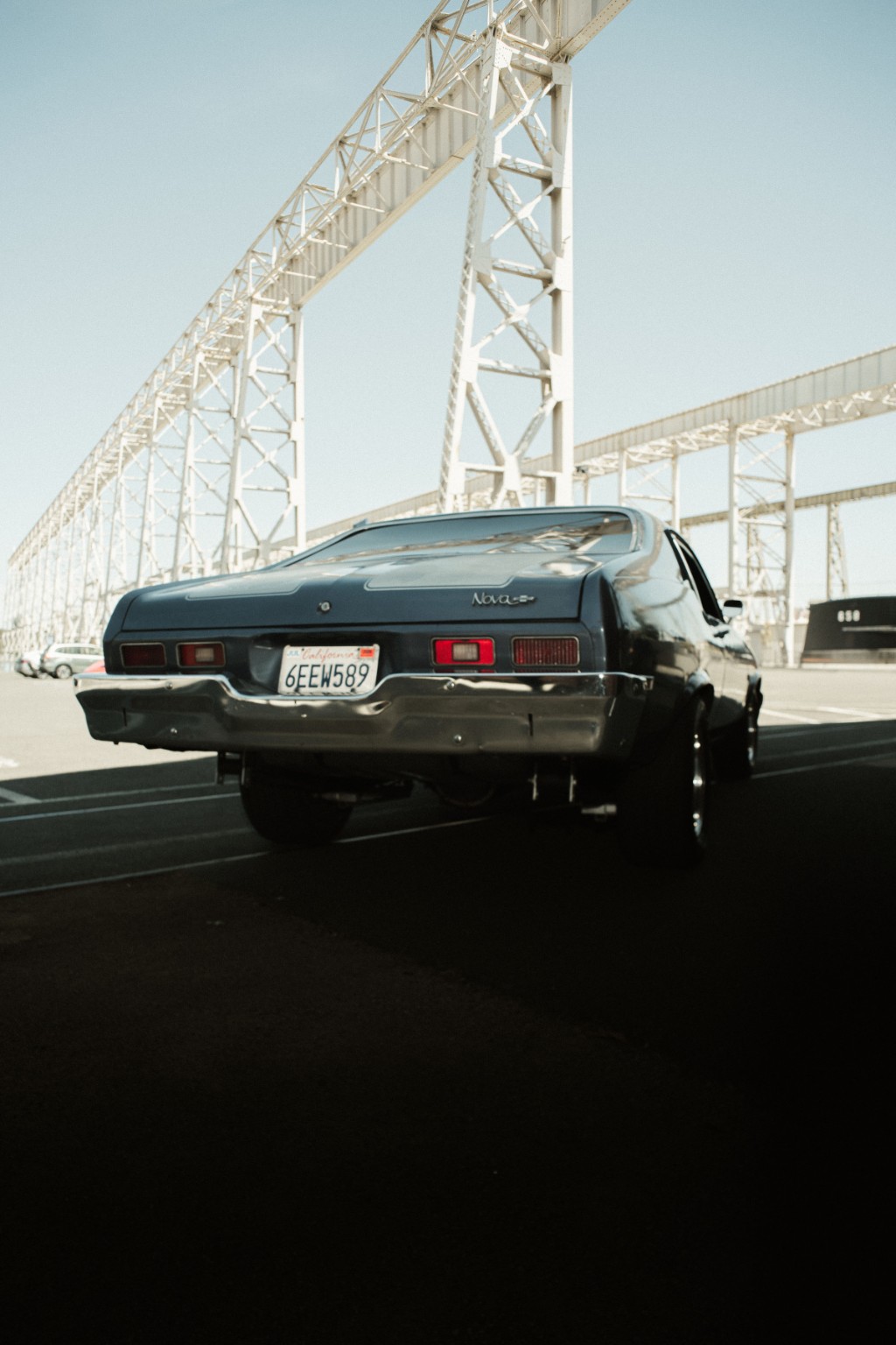 Classic Chevrolet Nova photographed beneath an industrial structure